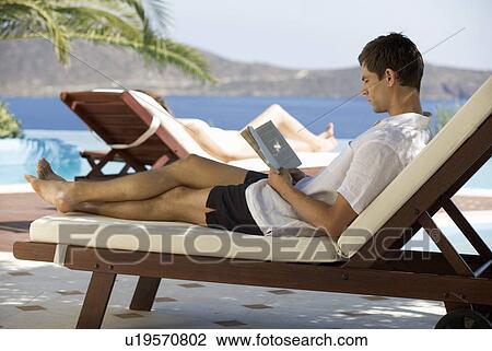 Two people relaxing by a pool View Large Photo Image Stock Image - Two people relaxing by a pool. Fotosearch