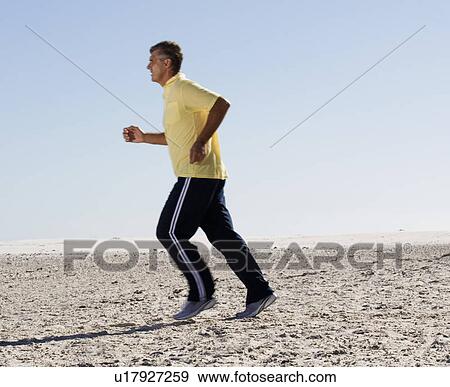 A man jogging on a beach View Large Photo Image Stock Photo - A man jogging on a beach. Fotosearch