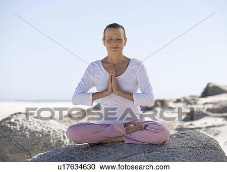 A mature woman performing yoga on a beach View Large Photo Image Stock Image - A mature woman performing yoga on a beach. Fotosearch