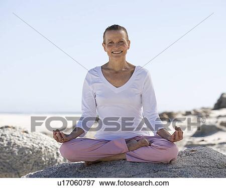 A mature woman performing yoga on a beach View Large Photo Image Stock Photo - A mature woman performing yoga on a beach. Fotosearch