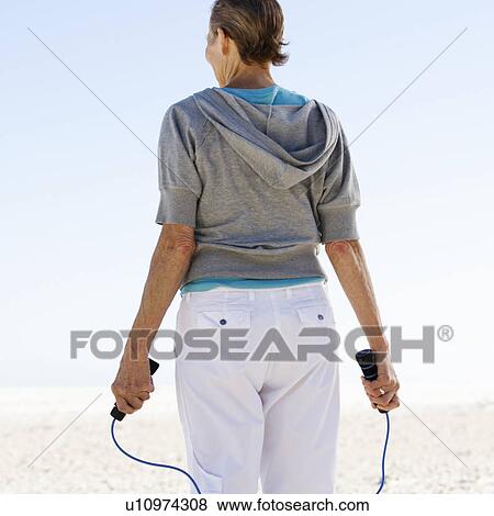 Stock Photo - A mature woman skipping. Fotosearch