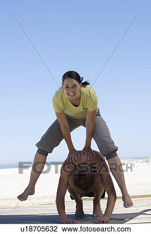 Stock Image - A young couple playing leap frog. Fotosearch