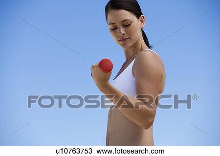 Stock Image - A young woman exercising. Fotosearch