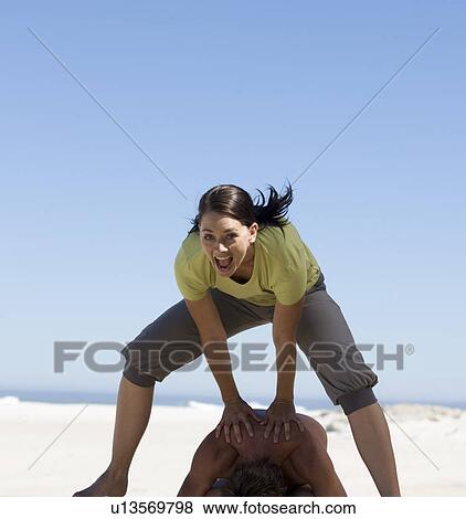 Stock Photo - A young woman playing leap frog. Fotosearch