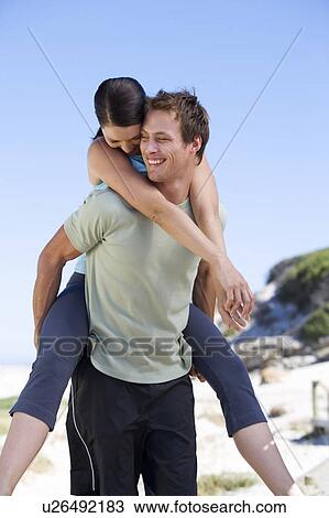 Portrait of a young couple, man giving woman piggyback View Large Photo Image Stock Image - Portrait of a young couple, man giving woman piggyback. Fotosearch