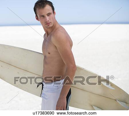 Young man with a surf board View Large Photo Image Stock Image - Young man with a surf board. Fotosearch