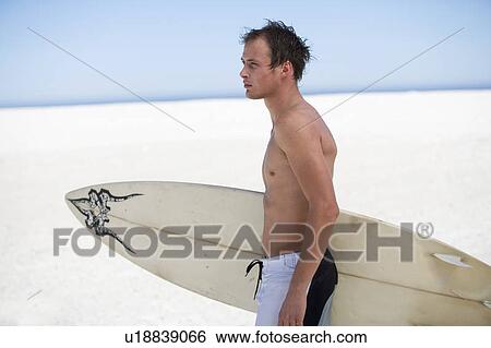 Stock Photograph - Young man with a surf board. Fotosearch