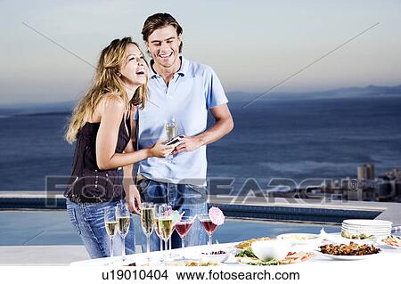Couple sharing a joke at a party View Large Photo Image Picture - Couple sharing a joke at a party. Fotosearch