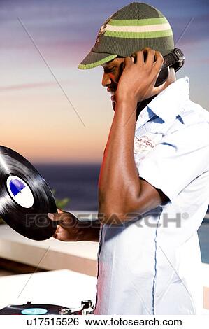 Stock Photograph - DJ selecting next record. Fotosearch