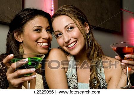 Two young women drinking cocktails View Large Photo Image Stock Image - Two young women drinking cocktails. Fotosearch