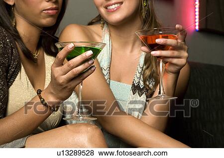 Two young women drinking cocktails View Large Photo Image Stock Photo - Two young women drinking cocktails. Fotosearch