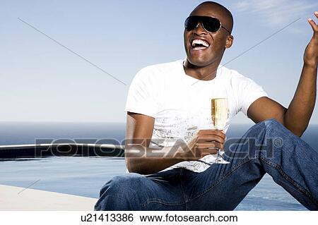 Young man drinking champagne by the pool View Large Photo Image Stock Photograph - Young man drinking champagne by the pool. Fotosearch