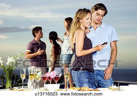 Young woman giving man her phone number at a party View Large Photo Image Stock Image - Young woman giving man her phone number at a party. Fotosearch