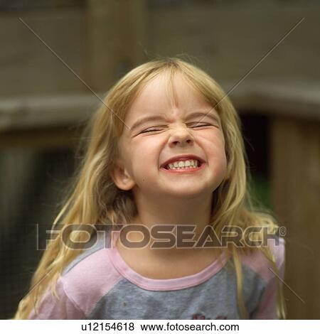 Stock Photo - 4 year old blond girl showing her teeth. Fotosearch