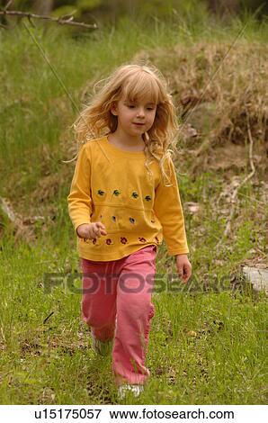 Blonde child running through field of grass View Large Photo Image Stock Photo - Blonde child running through field of grass. Fotosearch