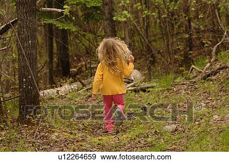 Stock Photo - Blonde child running through forest. Fotosearch