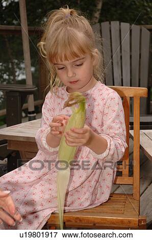 Small child pealing corn husk View Large Photo Image Stock Photo - Small child pealing corn husk. Fotosearch