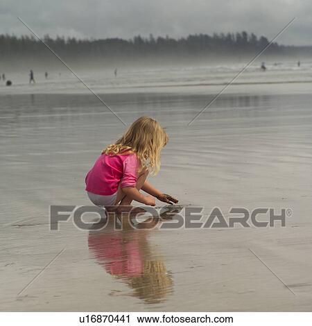 Young girl playing in wet sand View Large Photo Image Stock Image - Young girl playing in wet sand. Fotosearch