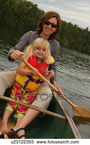 Stock Image - Young woman and her daughter paddling in a canoe. Fotosearch