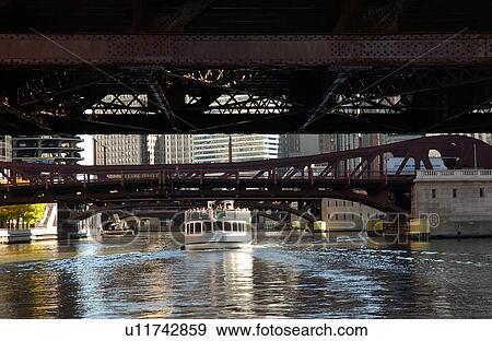 Boat passing under a bridge View Large Photo Image Stock Photo - Boat passing under a bridge. Fotosearch