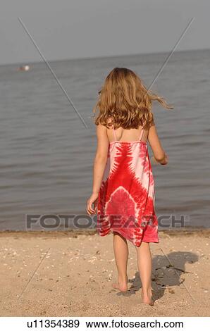 Stock Photo - 5 year old on beach walking towards lake. Fotosearch