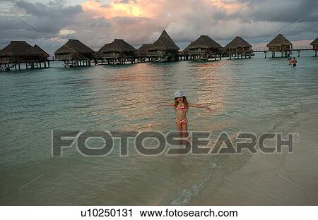 A young girl (6-8) playing on a beach View Large Photo Image Stock Image - A young girl (6-8) playing on a beach. Fotosearch