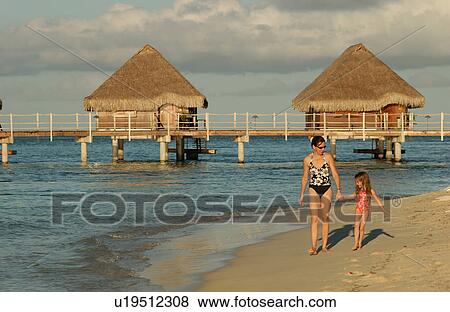 A young woman walking on the beach with her daughter View Large Photo Image Stock Photo - A young woman walking on the beach with her daughter. Fotosearch
