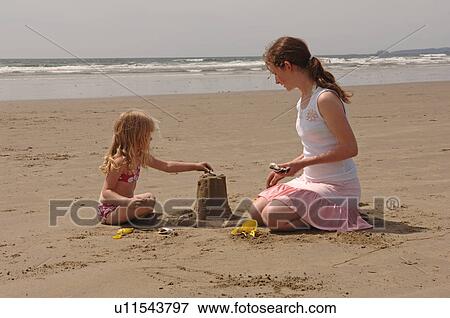Children playing in sand on beach View Large Photo Image Stock Photo - Children playing in sand on beach. Fotosearch