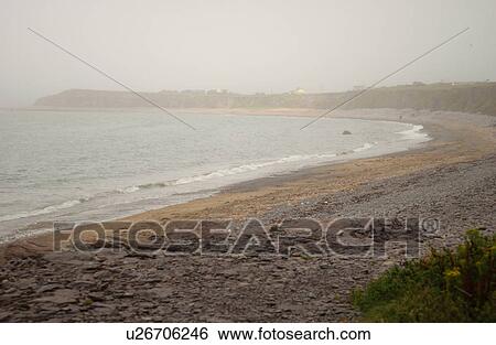 Stock Photograph - Ireland - rocks on beach in fog. Fotosearch