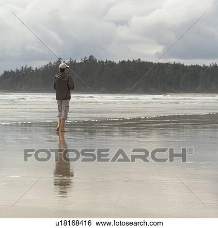 Woman standing on beach View Large Photo Image Stock Photograph - Woman standing on beach. Fotosearch