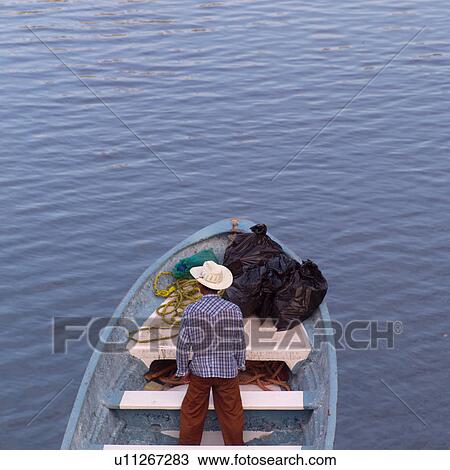 Man standing alone on a boat View Large Photo Image Stock Image - Man standing alone on a boat. Fotosearch