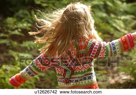 Stock Image - Rear view of a young girl jumping. Fotosearch