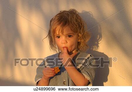 Stock Photograph - Toddler eating cookie. Fotosearch