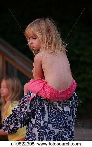 Young girl sitting on an adult's shoulders View Large Photo Image Stock Photography - Young girl sitting on an adult's shoulders. Fotosearch