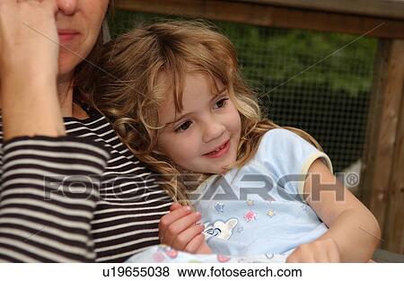 Young girl smiling in her mothers arms View Large Photo Image Stock Photo - Young girl smiling in her mothers arms. Fotosearch