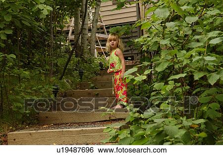 Stock Photograph - Young girl standing on stairs looking down. Fotosearch