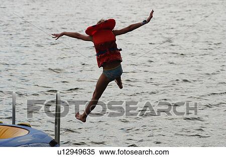 Young girl wearing a lifejacket jumping of a raft View Large Photo Image Stock Photography - Young girl wearing a lifejacket jumping of a raft. Fotosearch