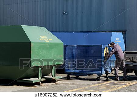 Stock Image - Man moving large containers. Fotosearch