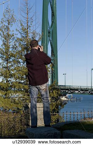 Man taking photo of Lions Gate Bridge View Large Photo Image Stock Photo - Man taking photo of Lions Gate Bridge. Fotosearch