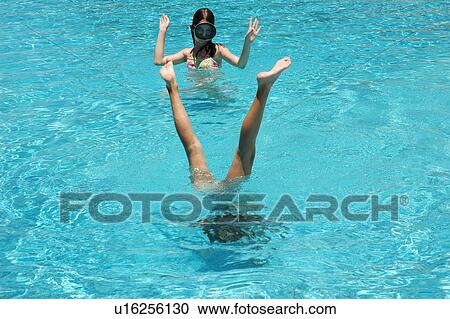 A young girl looking at a man standing upside down in a swimming pool, Moorea, Tahiti, French Polynesia, South Pacific View Large Photo Image Stock Image - A young girl looking at a man standing upside down in a swimming pool, Moorea, Tahiti, French Polynesia, South Pacific. Fotosearch