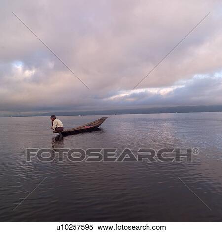 Intha fisherman in his flat-bottomed boat View Large Photo Image Stock Photography - Intha fisherman in his flat-bottomed boat. Fotosearch