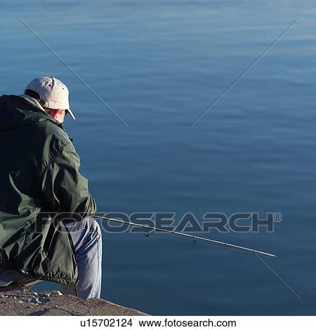 Rear view of a young man fishing View Large Photo Image Picture - Rear view of a young man fishing. Fotosearch