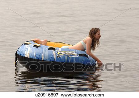 Teenager floating on a raft View Large Photo Image Stock Photo - Teenager floating on a raft. Fotosearch