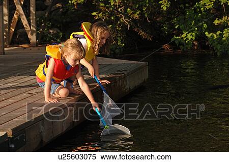 Two girls with nets at edge of dock View Large Photo Image Stock Photography - Two girls with nets at edge of dock. Fotosearch