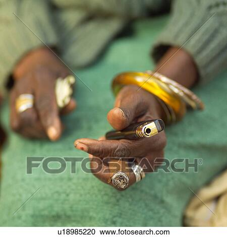 Close-up of a woman's hands holding a cigarette lighter and a cigar, Havana, Cuba View Large Photo Image Stock Image - Close-up of a woman's hands holding a cigarette lighter and a cigar, Havana, Cuba. Fotosearch