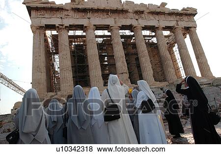 Stock Photo - Group of nuns looking at an ancient historical building in Athens, Greece. Fotosearch