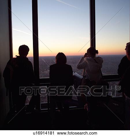 Stock Image - Silhouette of people looking through a window. Fotosearch