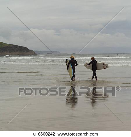 Stock Image - Surfers with surfboards on beach, Pacific Rim Park, Vancouver Island, Canada. Fotosearch