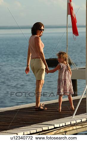 Stock Image - A young woman with her daughter (6-8) on a pier. Fotosearch