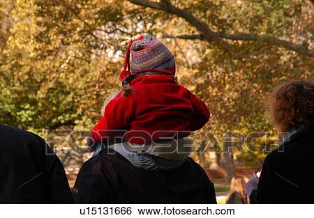 Child sitting on shoulders of adult View Large Photo Image Stock Photograph - Child sitting on shoulders of adult. Fotosearch